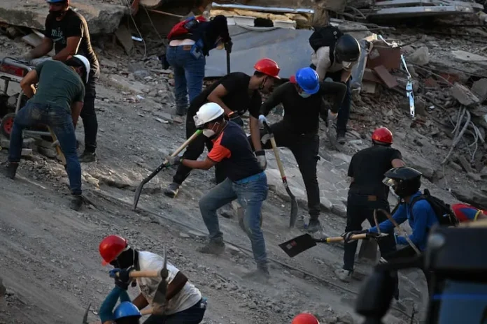 Venezolanos buscan desaparecidos entre escombros.