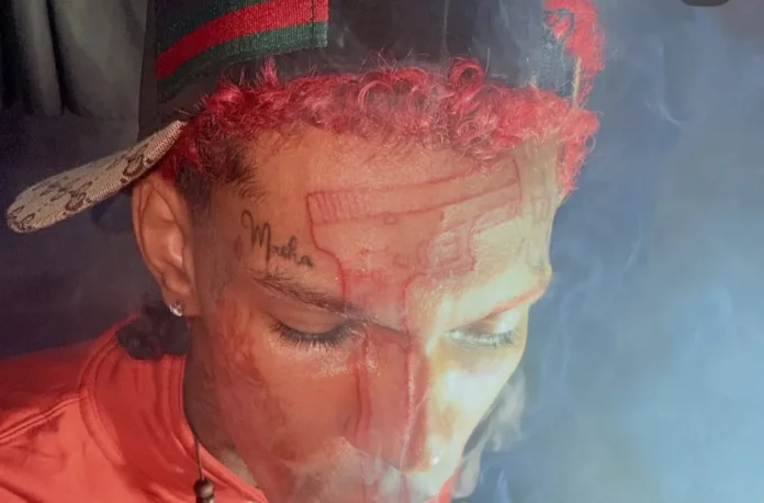 Dilon Baby con tatuaje de Glock en frente.